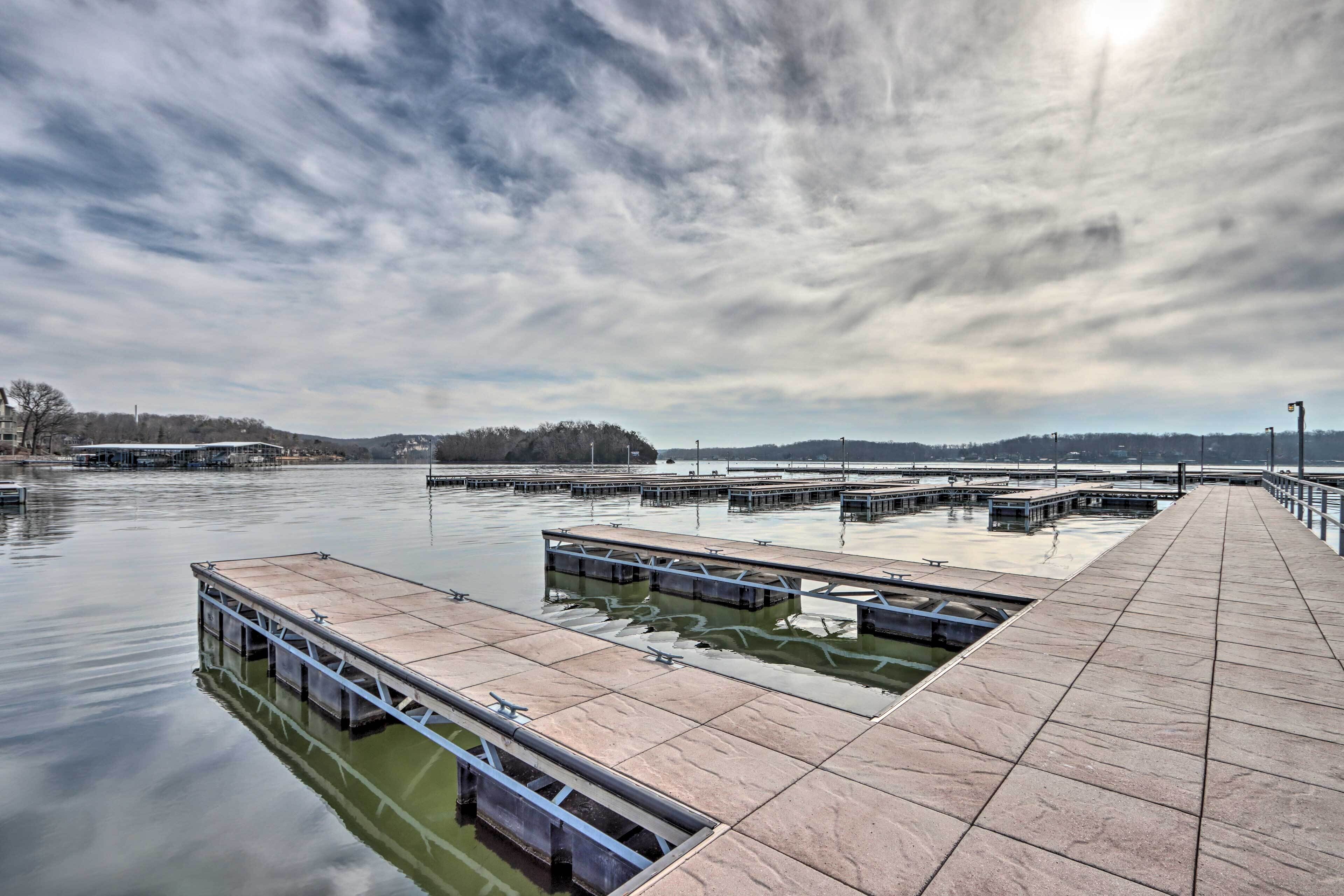 Eine Uferpromenade mit mehreren Anlegestegen, die sich in ruhiges Wasser erstrecken, umgeben von einer hügeligen Landschaft.