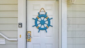 A white door with a blue ship's wheel decoration, a doorbell, and a mailbox. - 2 Mi to Beach: Pool-view Myrtle Beach Escape! (Myrtle Beach)