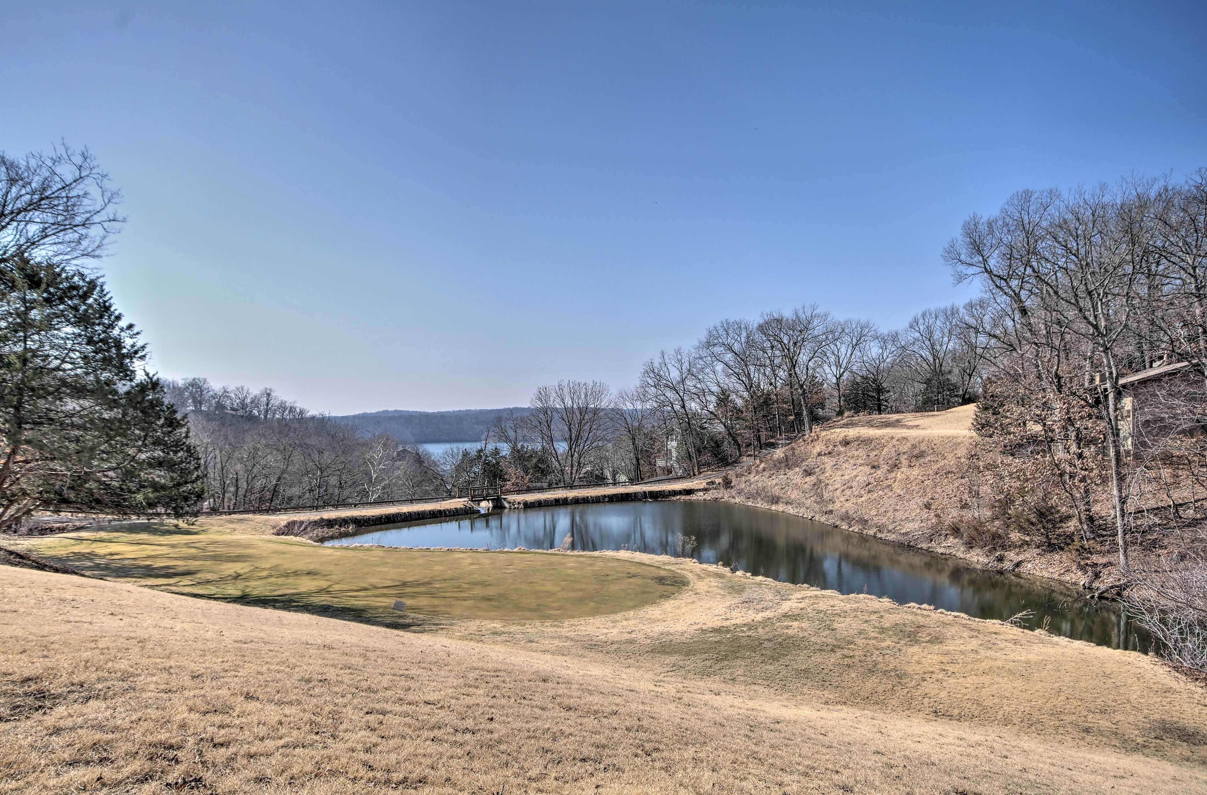 A serene landscape with a river, grassy areas, and trees.