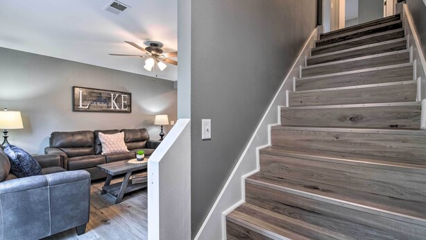 A staircase with wooden steps and white railings, leading to an upper floor. - Pet-friendly Abode, Walk to Table Rock Lake! (Kimberling City)