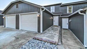A two-story house with a garage, a front door, and a small porch area. - Pet-friendly Abode, Walk to Table Rock Lake! (Kimberling City)