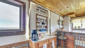 Une cuisine rustique avec des meubles en bois, un coin café et une vue sur l’extérieur.