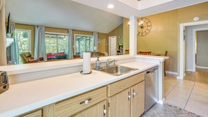 A modern kitchen with a large island, a built-in dishwasher, and a large window with curtains. - 2 Decks & Pool Access: Osage Beach Retreat (Osage Beach)