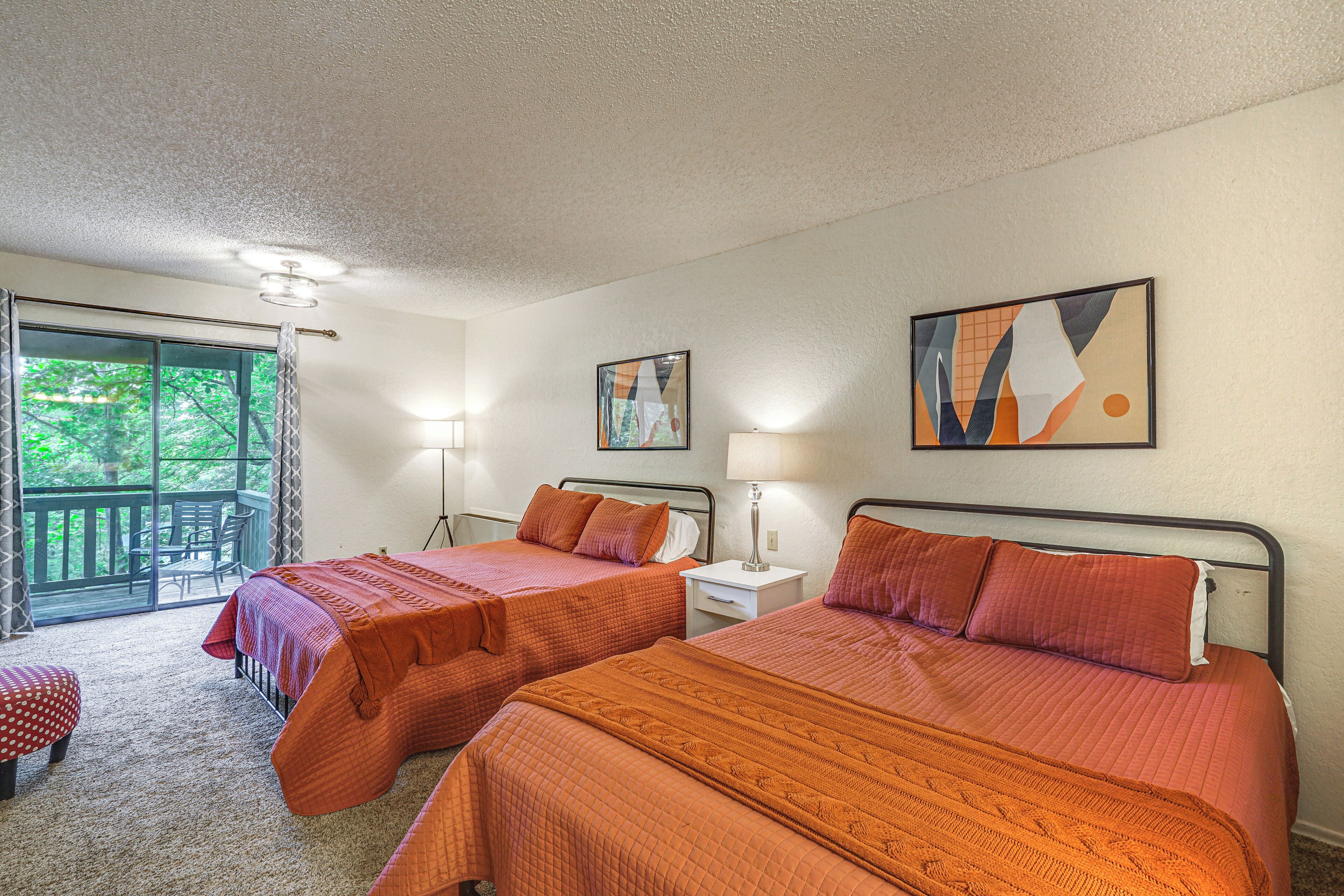 A room with two beds, a window with curtains, a chair, and a table.
