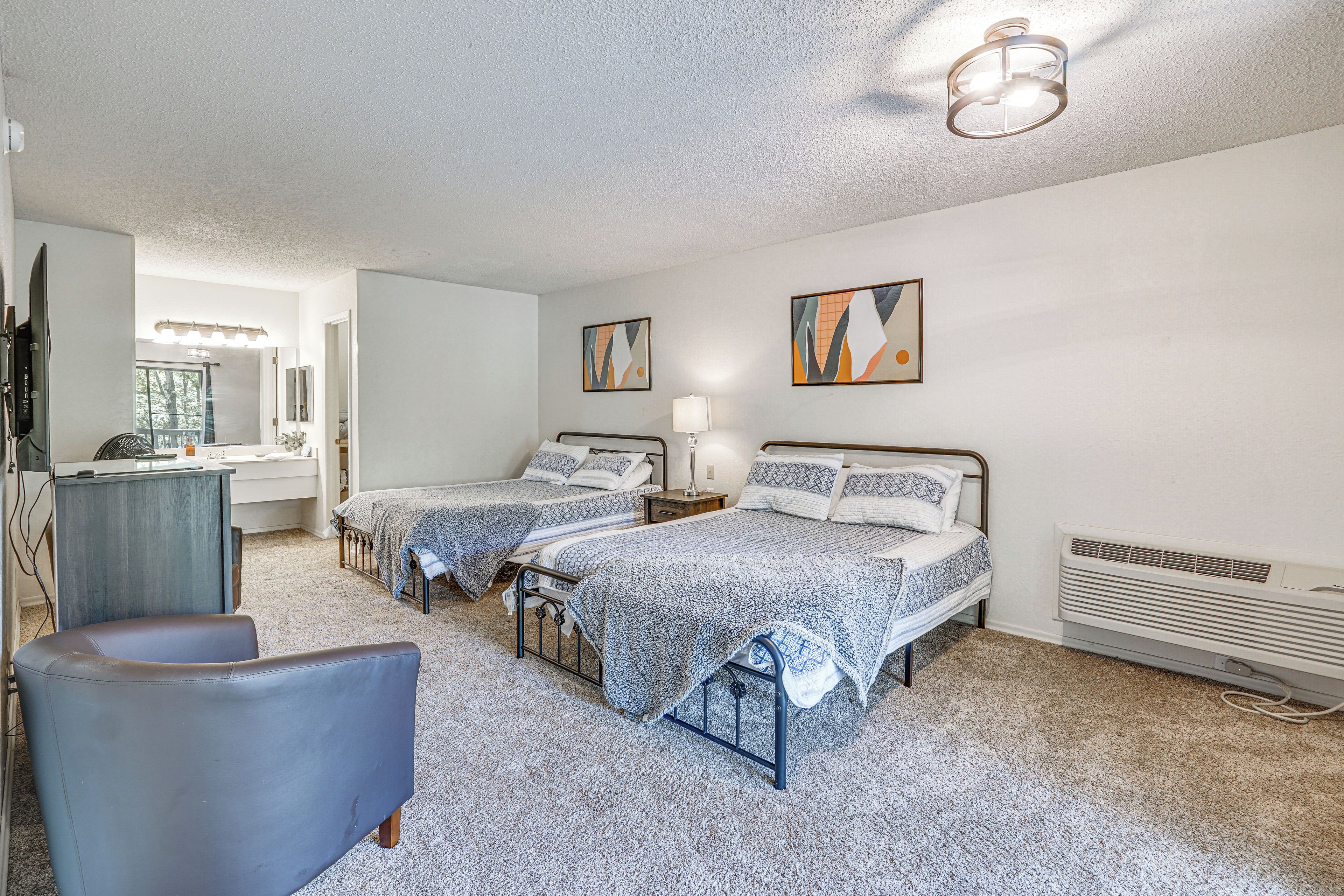 A bedroom with two beds, a desk, a chair, and a radiator.
