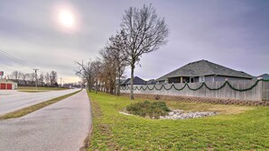 Un quartier résidentiel comprenant une maison, une route asphaltée et une zone herbeuse.
