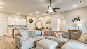 A modern living room with a sectional sofa, a dining area, and a kitchen. - Family-friendly Ozark Villa - Centrally Located (Ozark)