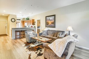 Ein Wohnzimmer mit einer Couch, einem Sessel, einem Couchtisch und einem Teppich.