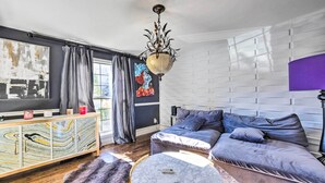 Un salon moderne avec un canapé d’angle, une table basse en marbre, un meuble décoratif et un lustre.