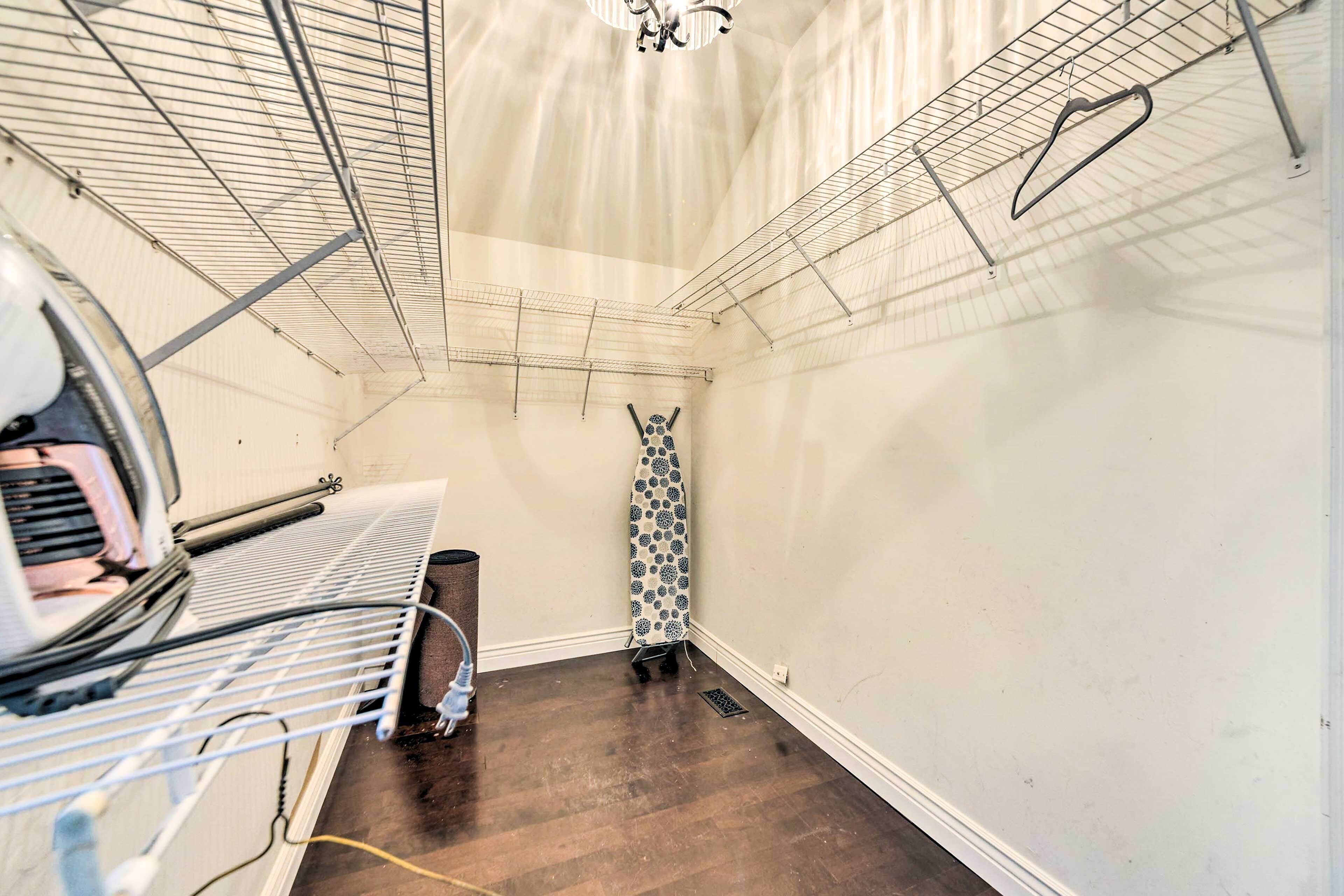 Una lavanderia con rastrelli metallici per stendere, un ferro da stiro a parete e un asse da stiro decorato.