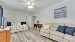 Una sala de estar con un sofá color crema, un sofá estampado con motivos florales y una mesa de centro de madera.