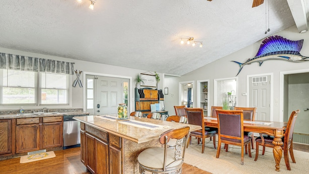 A spacious kitchen with wooden cabinets, a stainless steel dishwasher, and a large island with bar stools. - Deck & Table Rock Lake View: Shell Knob Escape! (Shell Knob)