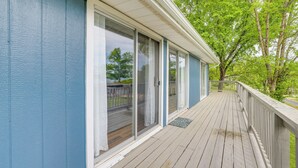 A covered porch with a wooden deck, sliding glass doors, and a view of a green landscape. - Deck & Table Rock Lake View: Shell Knob Escape! (Shell Knob)