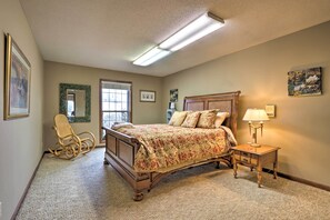 Classic bedroom with a large bed, wooden rocking chair, and bedside table.