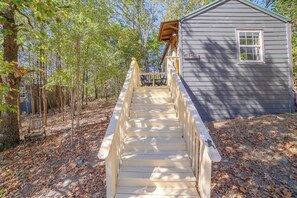 A wooden staircase leading to a small house with a porch.