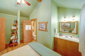 A bathroom with a wooden vanity, a sink, a mirror, and a towel rack.
