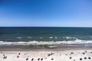 A beach with umbrellas and people.