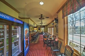Un restaurant doté d’un réfrigérateur de la marque Pepsi, d’une moquette à motifs et offrant une vue sur l’extérieur grâce à de grandes fenêtres.