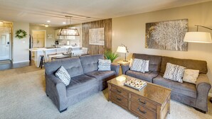 A living room with two sofas, a coffee table, and a kitchen in the background. - Pool, Pickleball, Proximity to Popular Attractions (Branson)