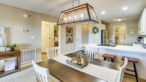 A modern kitchen with a central island, white cabinetry, and a pendant light above the island. - Pool, Pickleball, Proximity to Popular Attractions (Branson)