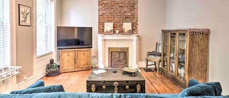 Una sala de estar con chimenea, televisor y aparador.