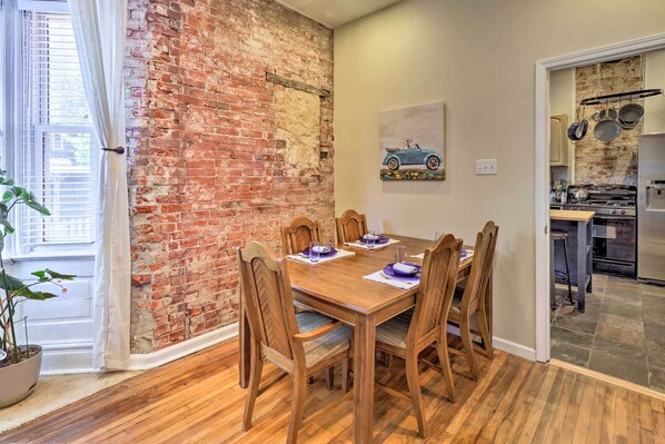 A dining area with a brick wall, wooden table, and chairs. - St Louis Retreat ~ 1 Mi to Botanical Garden (St. Louis)