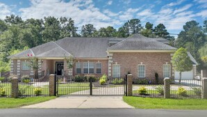 A two-story brick house with a front entrance, a covered porch, and a fenced yard. - 4 Mi to Dtwn: Simplistic Summerville Studio (Summerville)