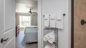 A hotel room with a bed, a walk-in closet, a shower area, and a towel rack. - Summerhouse Villas Condo: Private Resort Beach! (Pawleys Island)
