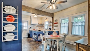 A spacious kitchen with a central island, white chairs, and a dining table. - Remodeled Historic Farmhouse ~ 20 Mi to KC! (Liberty)