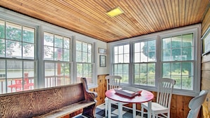 A room with a wooden ceiling, large windows, a bench, and a table with chairs. - Remodeled Historic Farmhouse ~ 20 Mi to KC! (Liberty)