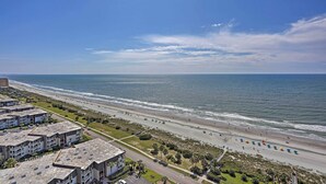 A coastal view with a beach, ocean, and residential buildings. - Community Pool Access: Condo in Myrtle Beach (Myrtle Beach)