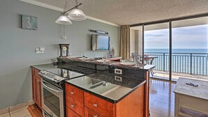 A kitchen with a large island, a dining area with a view of the ocean, and a balcony with a table and chairs. - Community Pool Access: Condo in Myrtle Beach (Myrtle Beach)