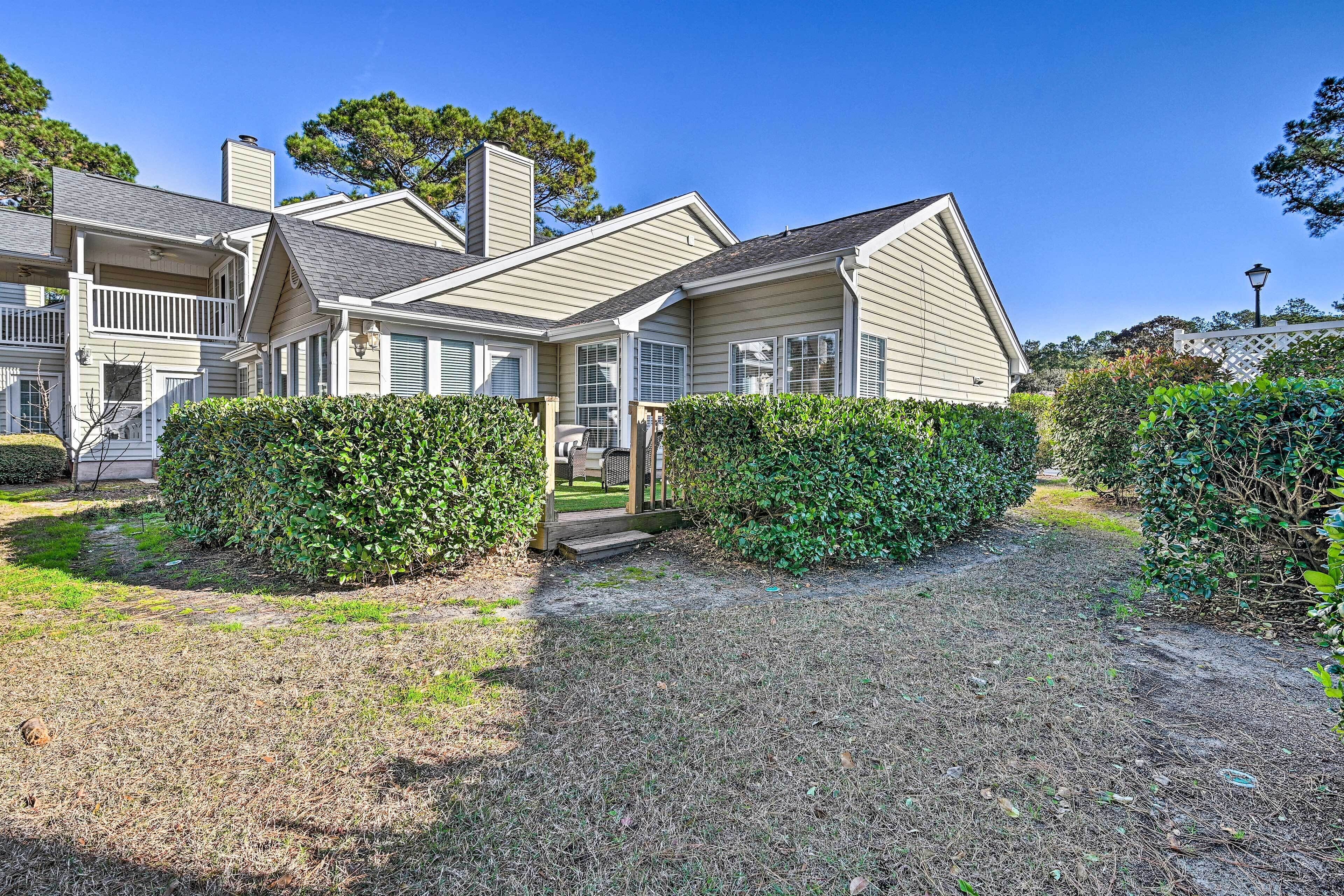 A two-story house with a covered porch, a chimney, and a well-maintained lawn.