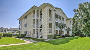 A multi-story residential building with balconies, a central staircase, and a well-maintained lawn. - Sunny N Myrtle Condo w/ Pool < 2 Mi to Beach! (North Myrtle Beach)