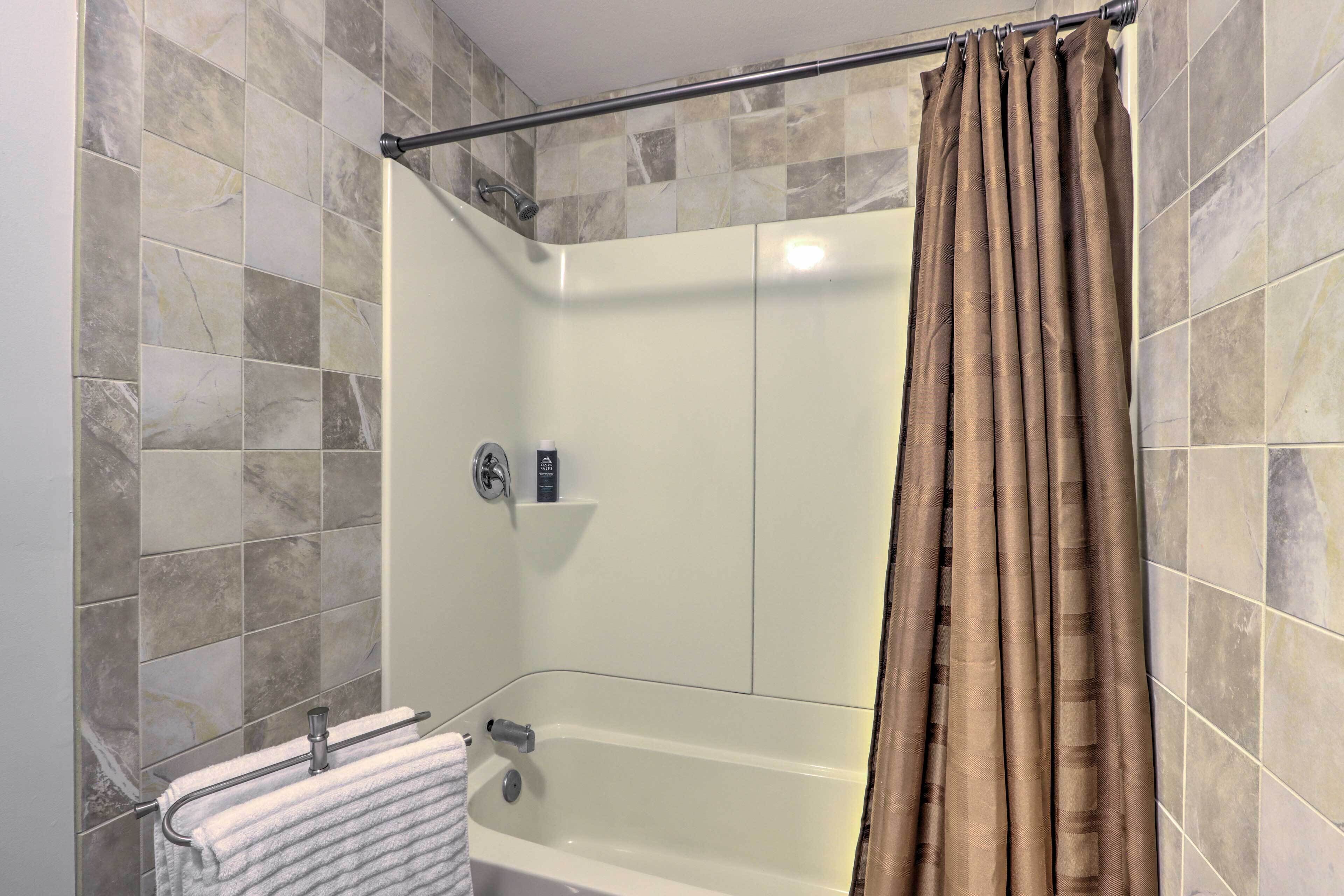 Ein Badezimmer mit Dusche, Badewanne und Handtuchhalter.