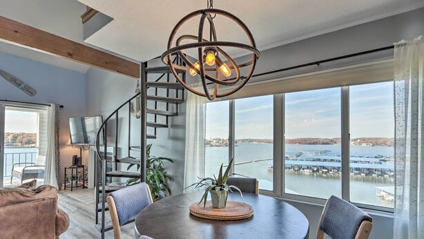 Un espace repas comprenant une table ronde, des chaises et un luminaire suspendu.