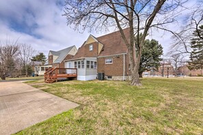 A residential house with a brick exterior, a covered porch, and a large lawn. - St Louis Vacation Rental 4 Mi to Airport! (St. Louis)