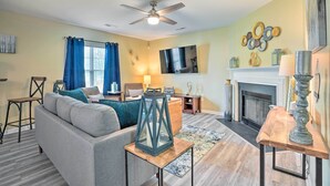 A living room with a sofa, a coffee table, a fireplace, and a ceiling fan. - Summerville Family Home ~ 20 Mi to Charleston (Summerville)