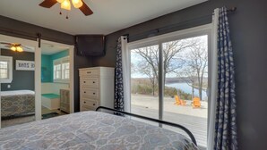 A bedroom with a bed, a dresser, a mirror, and a window with curtains. - Table Rock Lake Home - Fire Pit & Lake Views! (Golden)