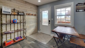 A room with a wooden wall, a door with frosted glass, a bench, and shelves with items. - Table Rock Lake Home - Fire Pit & Lake Views! (Golden)