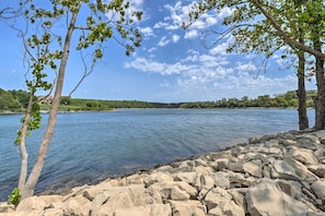A rocky shoreline with trees and a calm body of water. - Table Rock Lake Getaway w/ Fire Pit, Deck & Grill! (Golden)