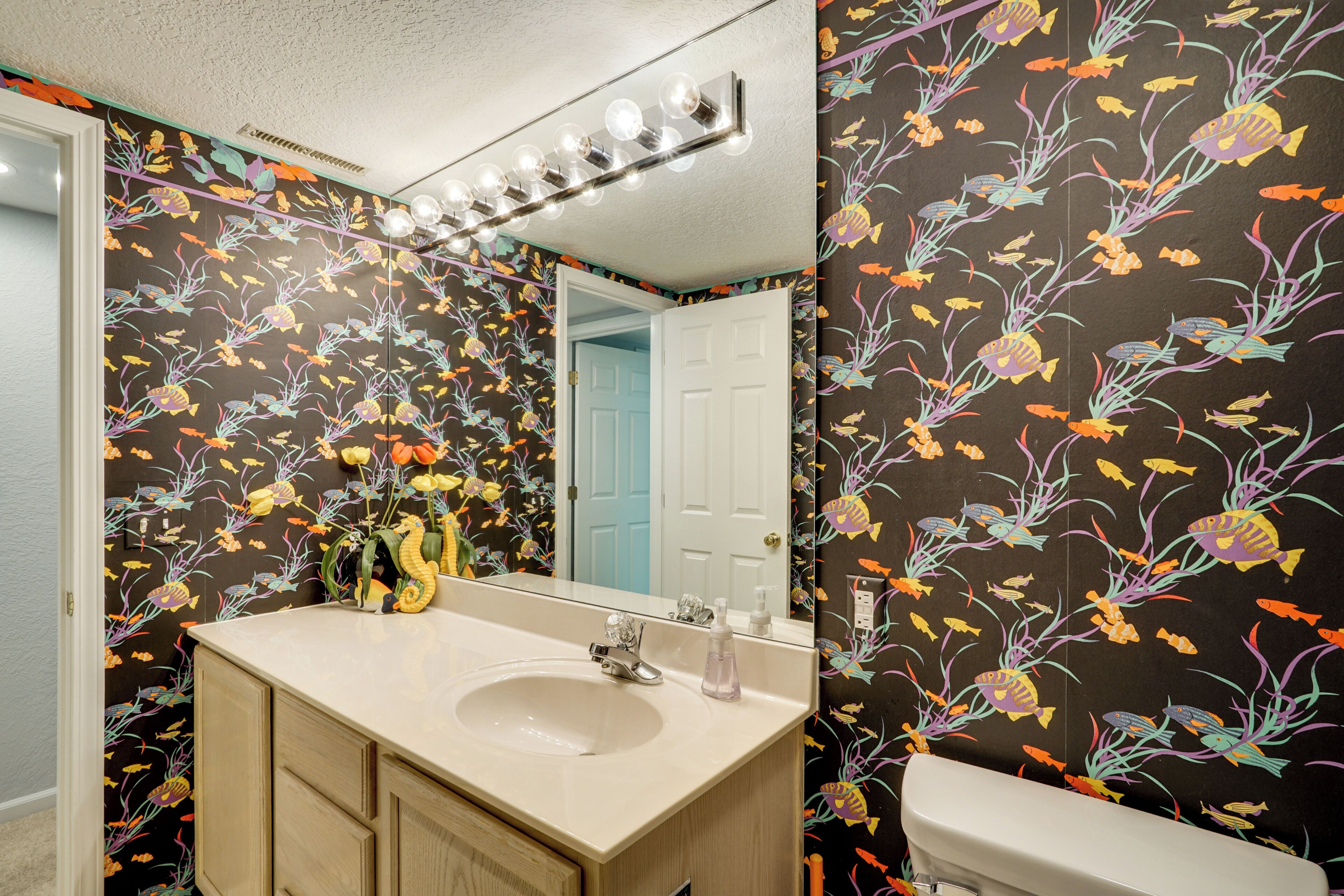 A bathroom with a sink, mirror, and toilet.