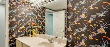 A bathroom with a sink, mirror, and toilet.
