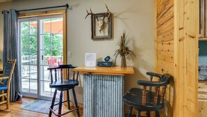 A wooden-framed desk with a mounted deer skull, two barstools, and a small plant. - Bull Shoals Lake Home w/ Porch - Steps to Water! (Cedarcreek)