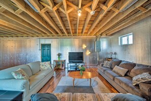 A spacious living room with wooden beams on the ceiling, a large flat-screen TV, two sofas, and a coffee table. - Updated Berger Cottage w/ Pool, on a Private Farm! (Berger)