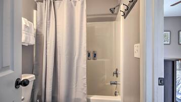 Un baño con ducha, inodoro y perchero.