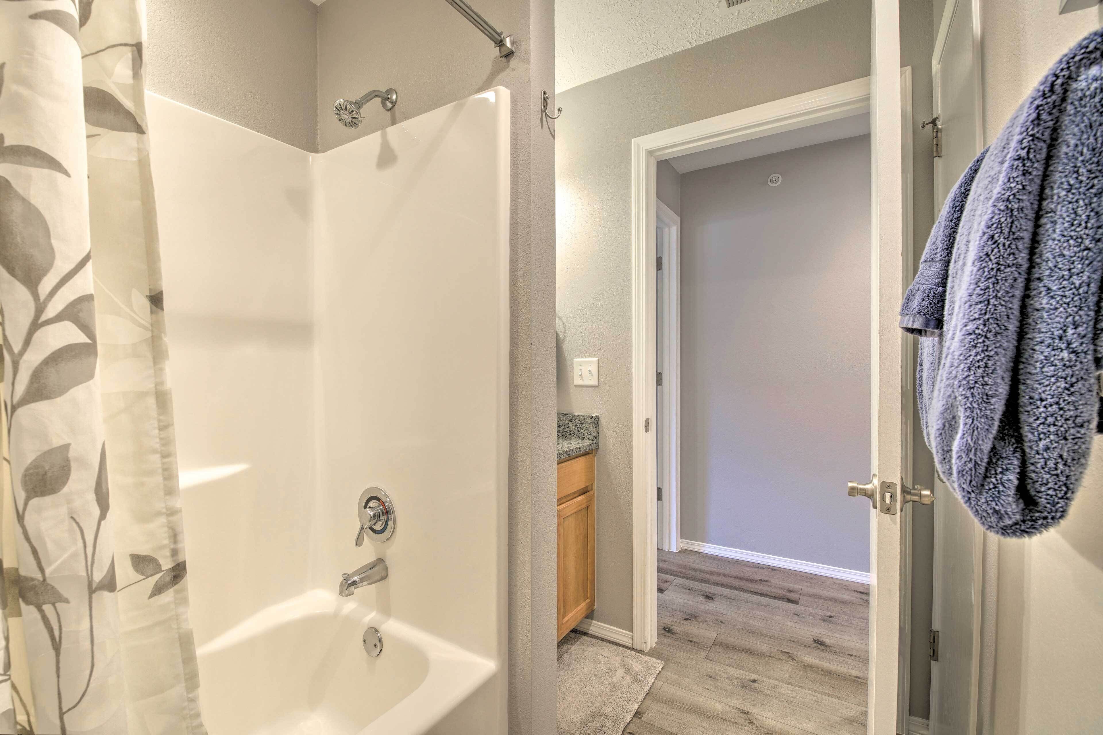 A bathroom with a shower, a toilet, and a sink.