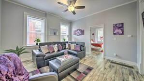 A spacious living room with a dark leather sofa, a glass coffee table, and a ceiling fan. - 9 Mi to Dtwn: Vibrant St Louis Home! (St. Louis)
