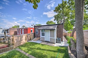 A residential backyard with a small brick house, a wooden fence, and a tree. - 9 Mi to Dtwn: Vibrant St Louis Home! (St. Louis)
