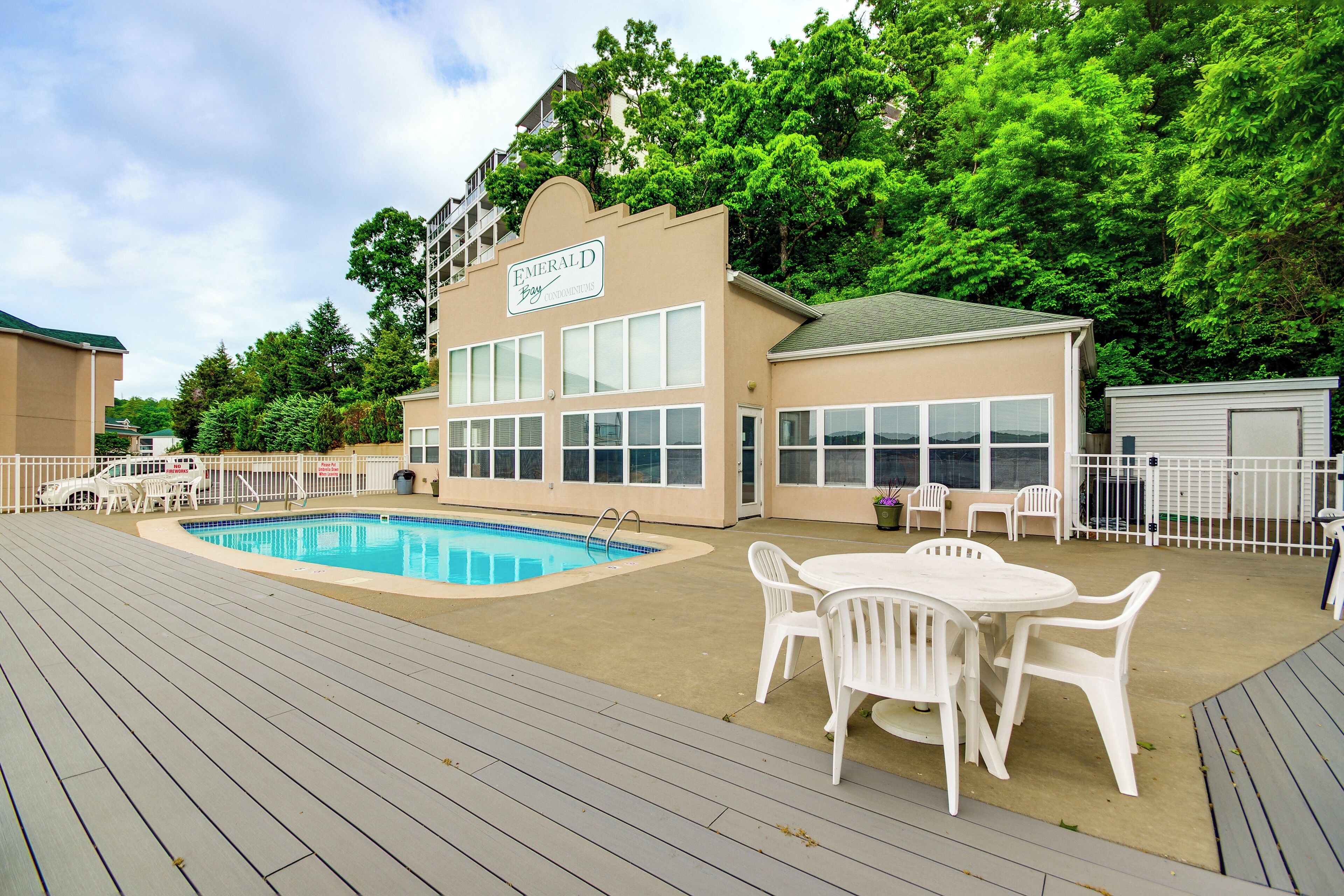 A pool area with a pool, lounge chairs, and a building labeled "Emerald Bay".
